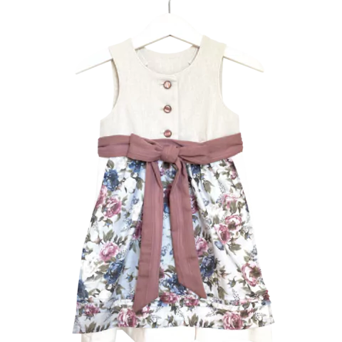 Babydirndl aus beigem Leinenoberteil mit passepoilliertem Ausschnitt und 3 Knöpfe. Creme-farbener Leinenrock mit Falten. Schürze ist geblümt mit einfärbigem Bund und Bänder zum binden.